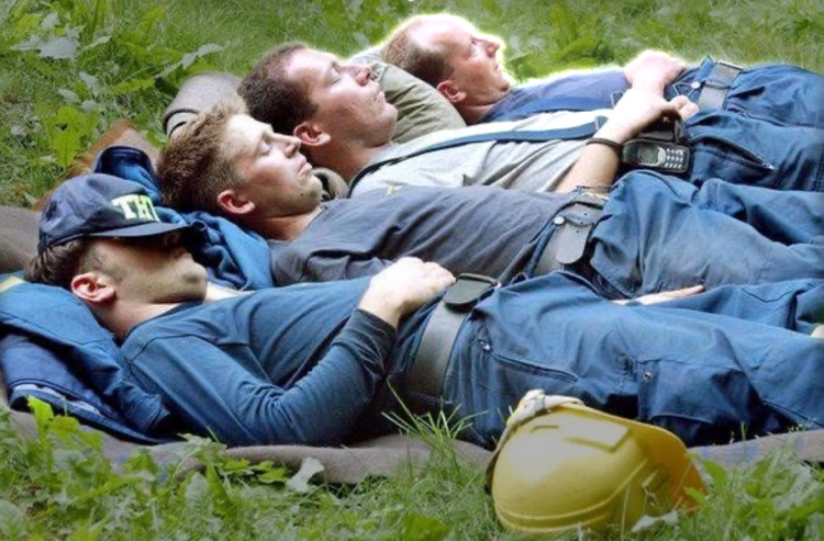 Miehiä makaamassa päiväunilla nurmikolla
